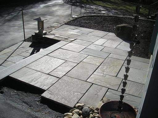 Bluestone patio with stone lantern and rain chain